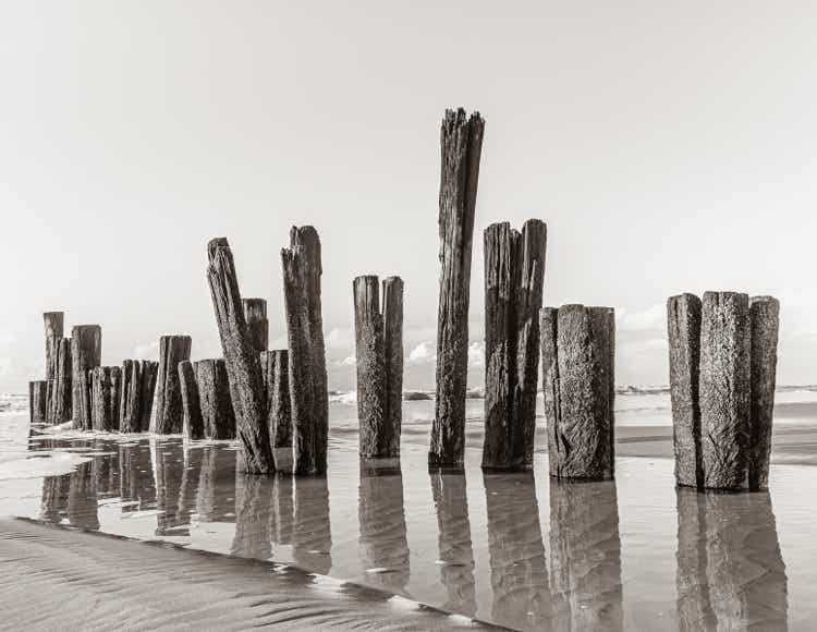 Foto van golbrekers op het strand in sepia.