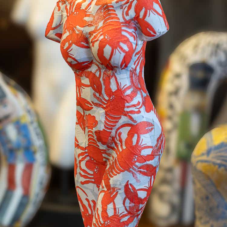 Een van de decoupage kunstwerken van Lisette Boer. Een model van een vrouw bedekt met afbeelding van rode kreeften. Aangebracht door decoupage technieken.
